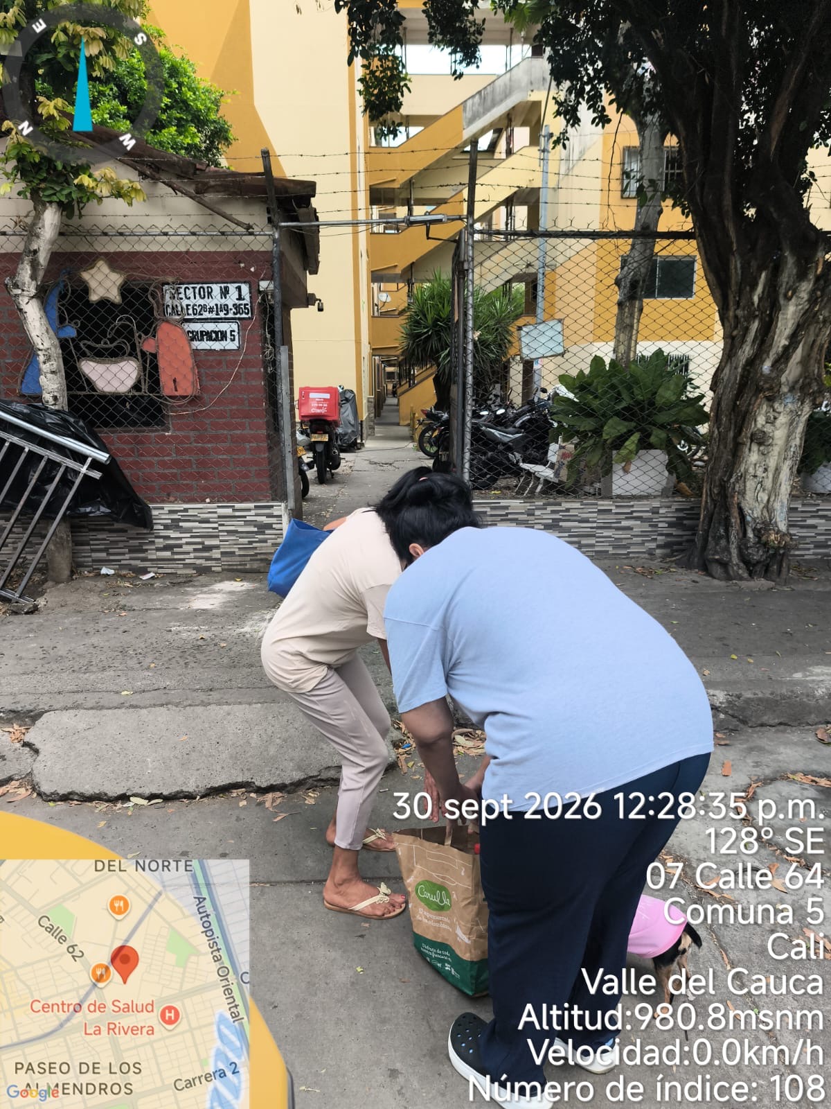 Dos personas organizan bolsas durante la entrega de almuerzos en Chiminangos II, el 30 de septiembre de 2026.