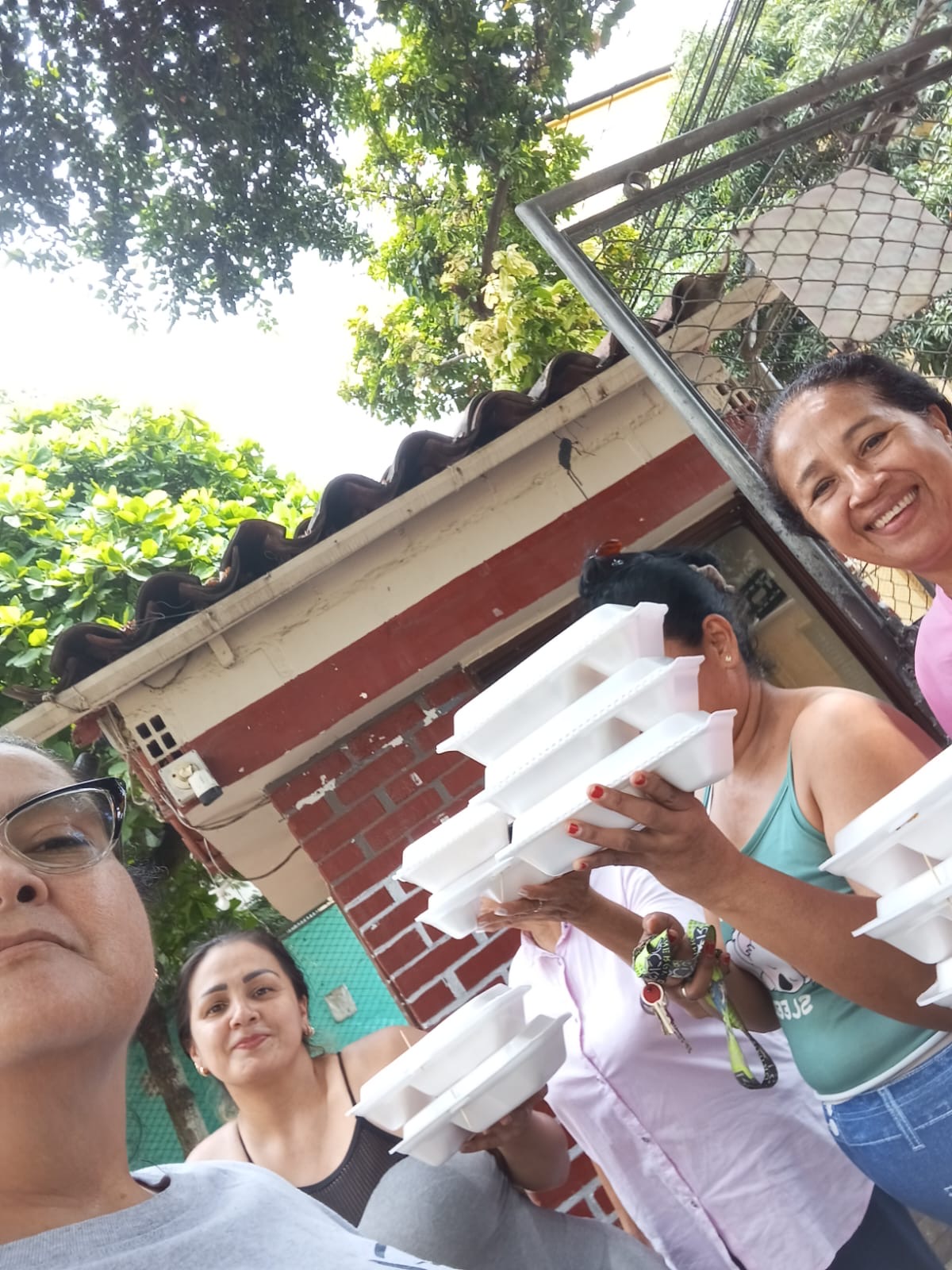 Personas de la comunidad de Chiminangos II con los almuerzos compartidos por la familia Arboleda.