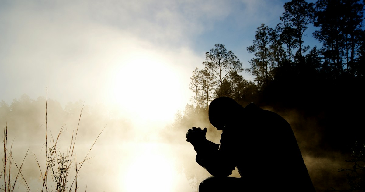 Silueta de un hombre orando al amanecer, imagen del paso de los rumores a la confesión personal